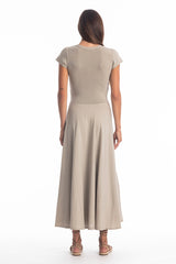 Woman wearing a long V-neck grey dress with short sleeves on a white background