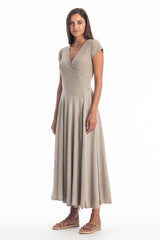 Woman wearing a long V-neck grey dress with short sleeves on a white background
