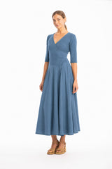 Woman wearing a V-neck long jeans blue dress with 3/4 sleeves on a white background