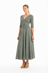 Woman wearing a V-neck long green dress with 3/4 sleeves on a white background