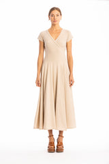 Woman wearing a long V-neck beige dress with short sleeves on a white background