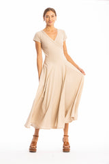 Woman wearing a long V-neck beige dress with short sleeves on a white background