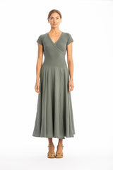 Woman wearing a long V-neck green dress with short sleeves on a white background