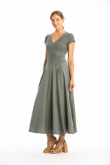 Woman wearing a long V-neck green dress with short sleeves on a white background