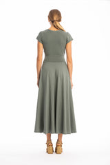 Woman wearing a green dress standing against a white background