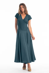 Woman wearing a long V-neck dark blue dress with short sleeves on a white background