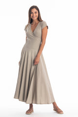 Woman wearing a long V-neck grey dress with short sleeves on a white background
