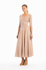 Woman wearing a V-neck long beige dress with 3/4 sleeves on a white background